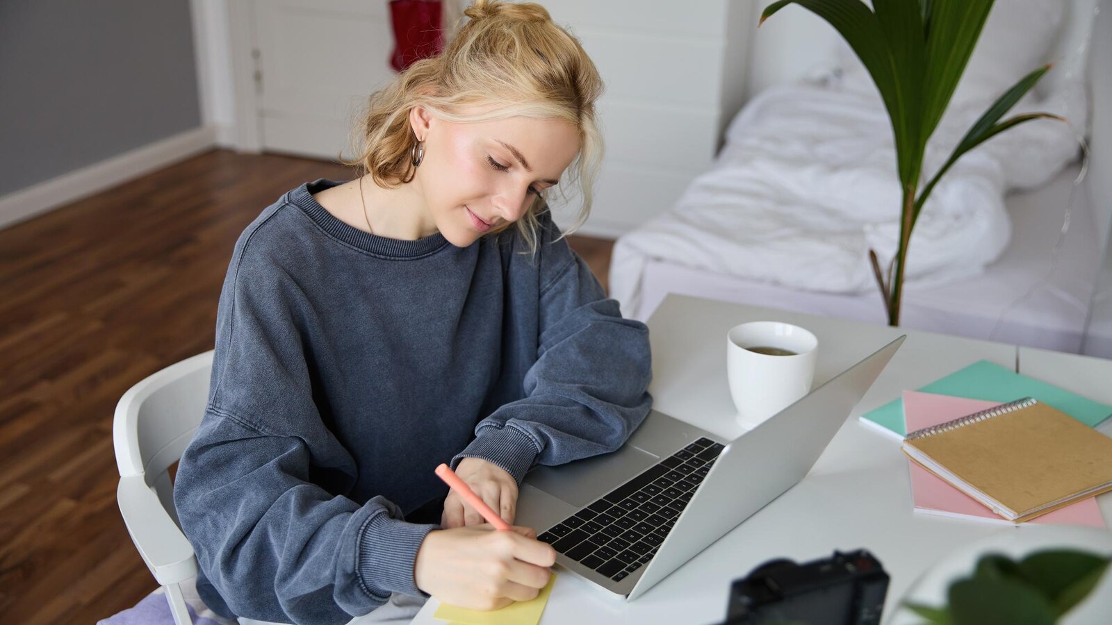 Student planning freelance tasks beside a laptop and handwritten notes
