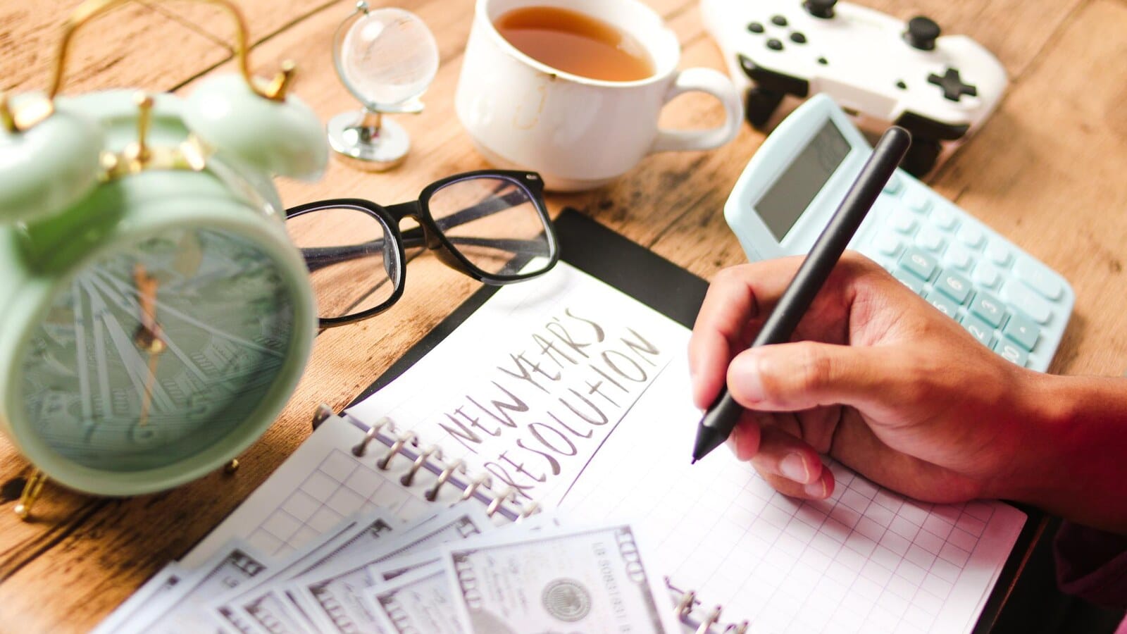 Video game controller beside a notebook on a desk