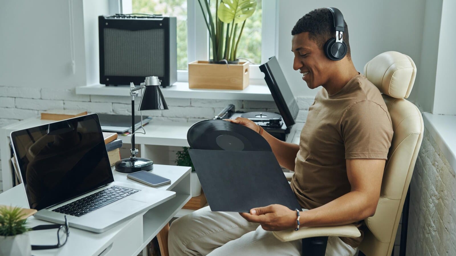 Gamer working at a laptop with chat windows and headphones on the desk