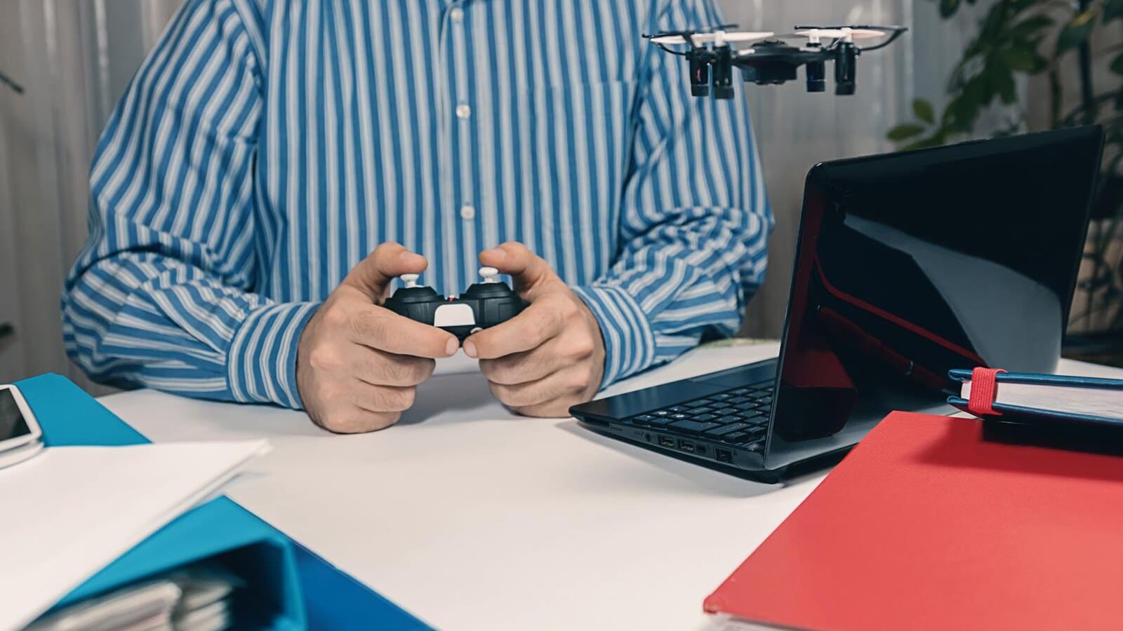 Gamer writing a game guide on a laptop with a controller nearby