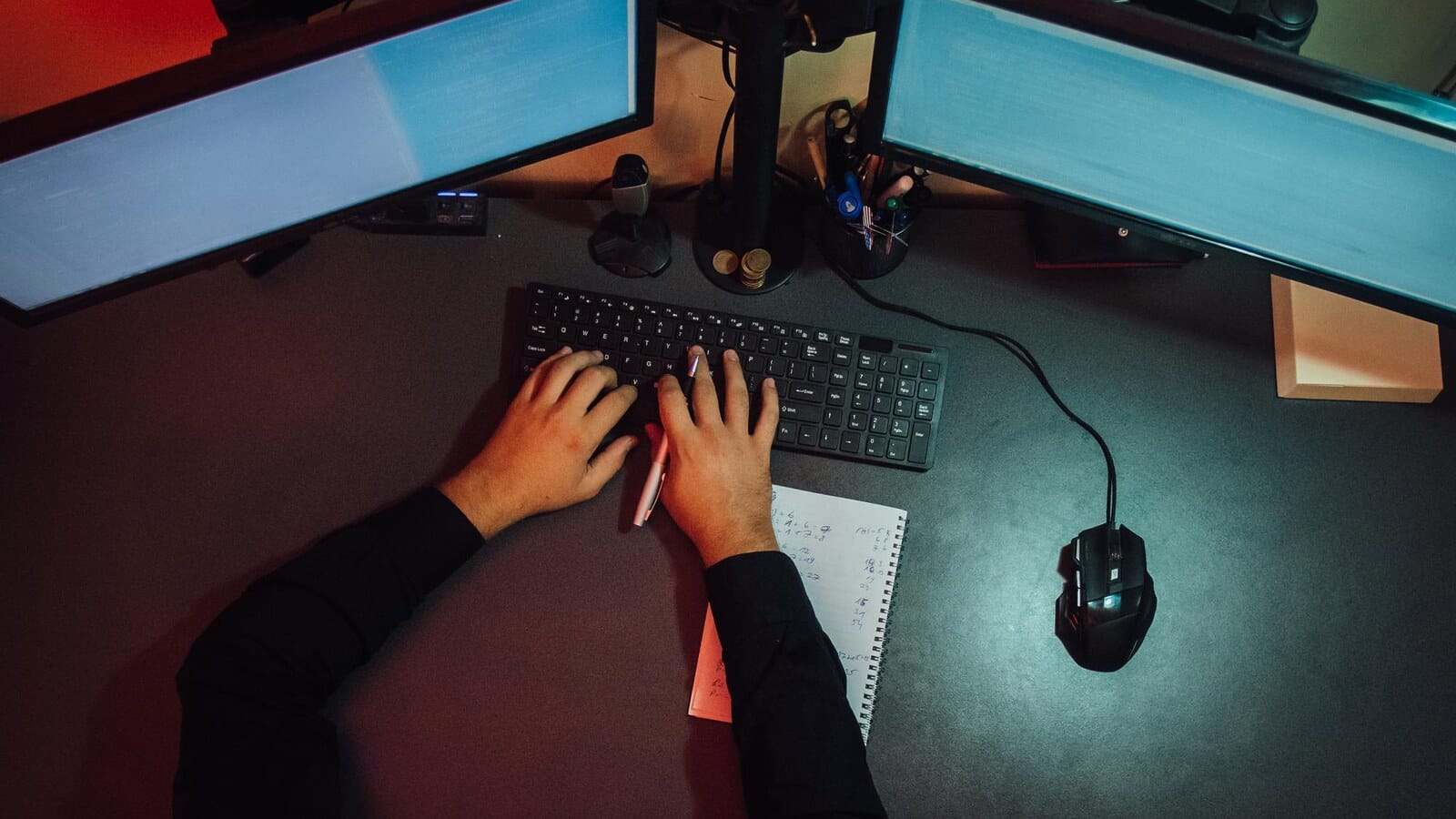 Gamer coding on a laptop with a controller on the desk