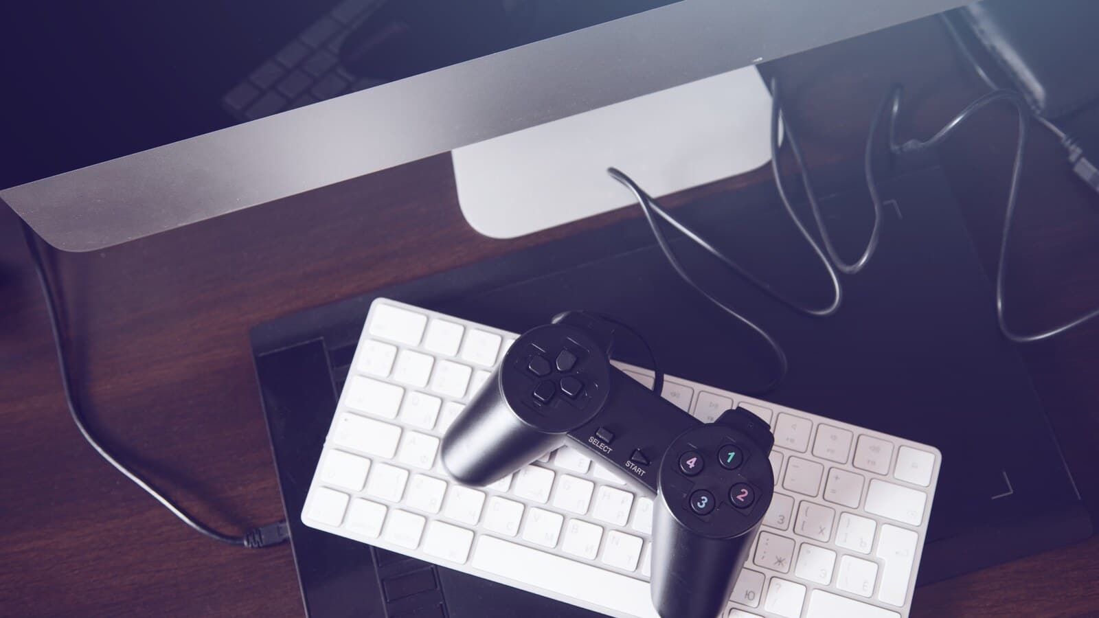 Gaming creator working on interface design with a laptop and controller nearby