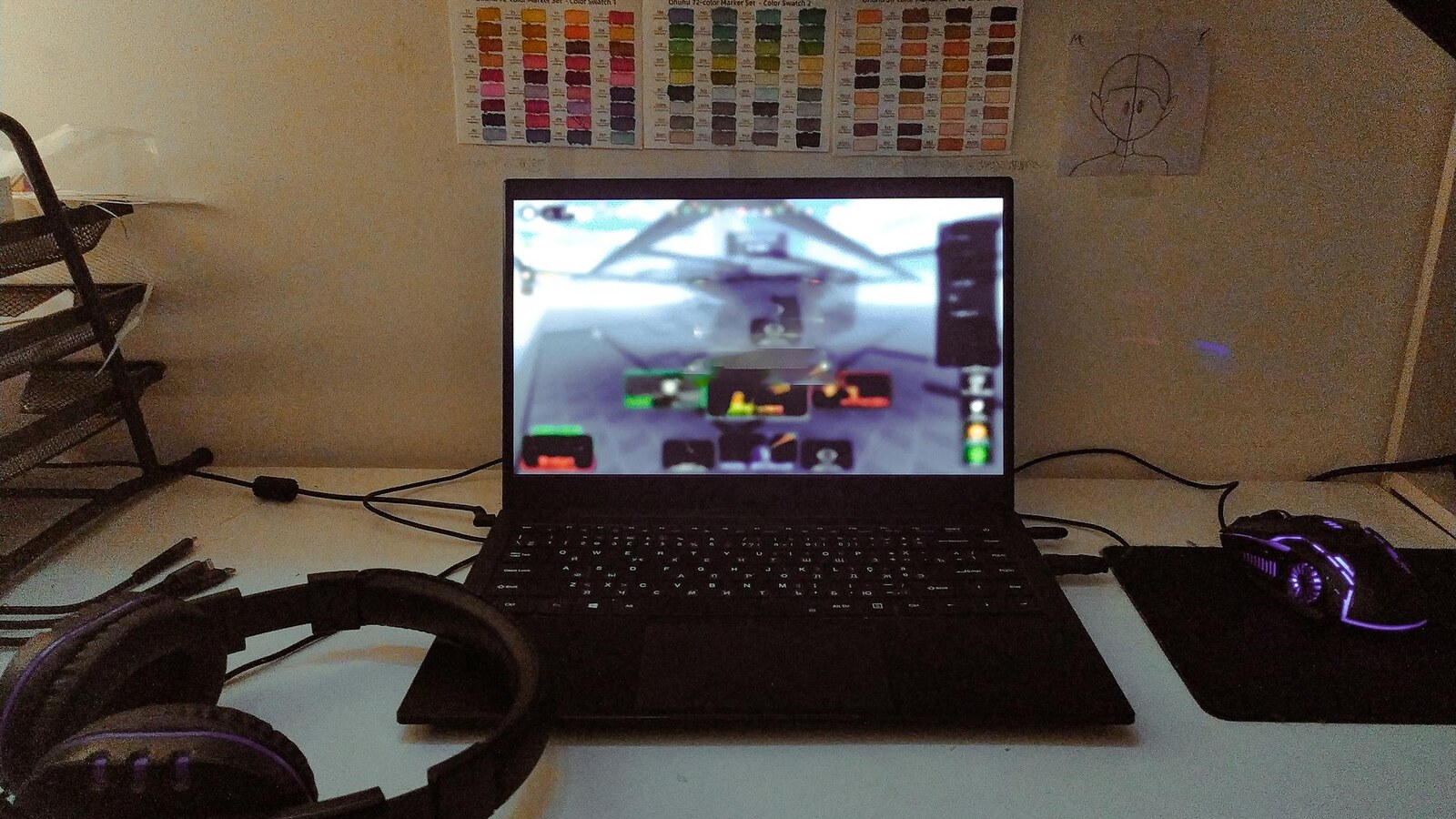 Gamer editing short video clips on a laptop beside a controller