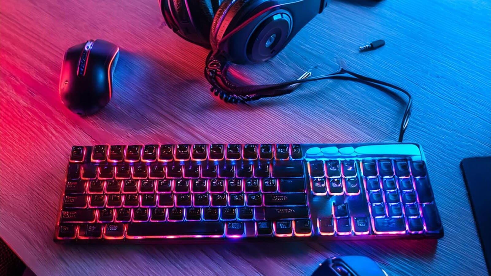 Gaming headset, keyboard, and controller on a desk after a match